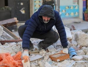 Depremde yıkılan iş yerinin enkazında takılarını arıyor
